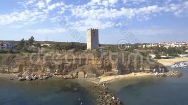 从空中俯瞰中世纪的塔在NeaFokea海滩和一艘小船在港口，Halkidiki希腊，向后移动博士